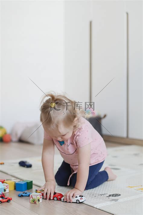 一个有趣的小女孩在托儿所的地板上玩立方体和玩具高清摄影大图 千库网