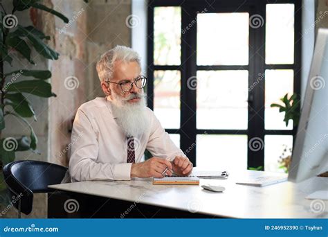 Focused Mature Businessman Working And Taking Notes In His Modern