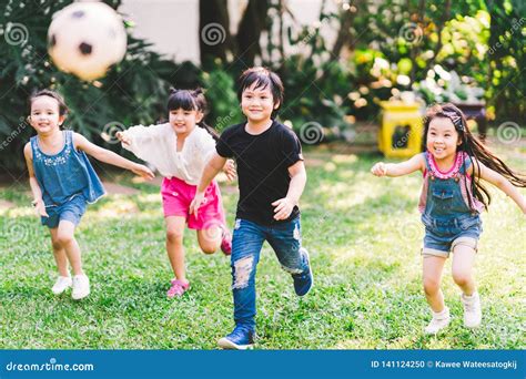 Asian and Mixed Race Happy Young Kids Running Playing Football Together ...