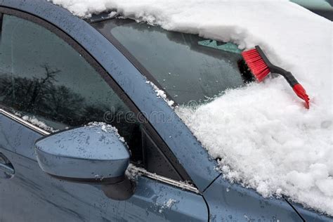 Brush For Clearing Automobile Is On The Hood Of The Car Snow Removing