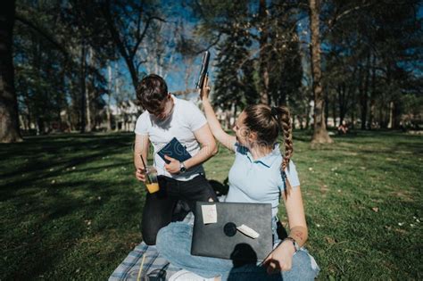 High School Students Collaborating On A Project In A Campus Park Stock