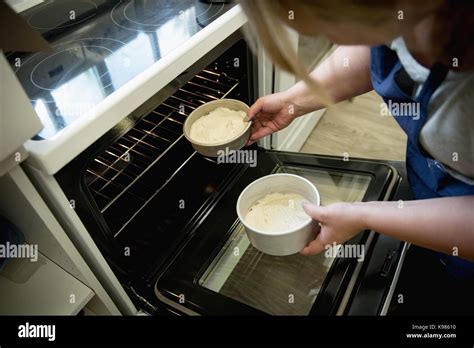 Woman putting cake into oven in the kitchen Stock Photo - Alamy