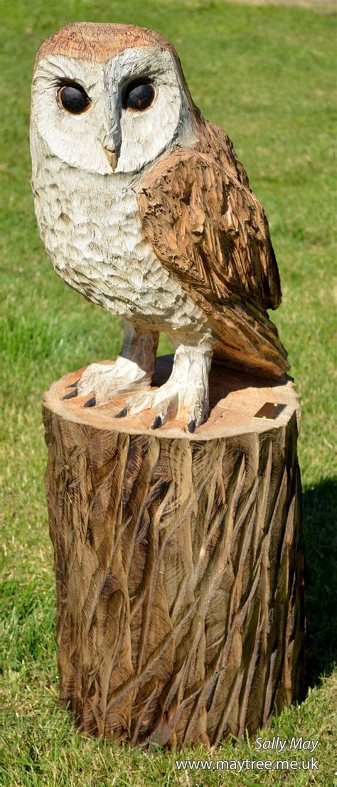 An Owl Statue Sitting On Top Of A Tree Stump