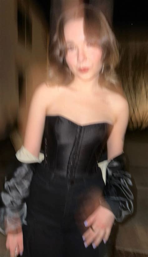 A Blurry Image Of A Woman In A Corset With Gloves On Her Arm