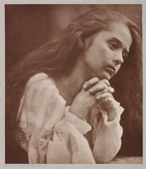 An Old Photo Of A Woman With Her Hands Clasped In Front Of Her Face And