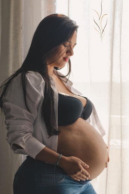 Premium Photo Pregnant Latina Woman Looking And With Her Hands On Her