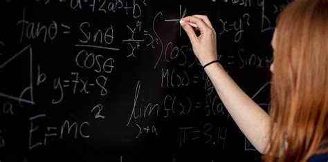 Actuarial science student writing formulae on a blackboard