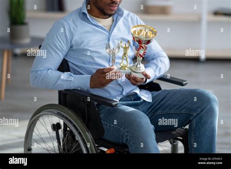 Cropped View Of Handicapped Black Guy In Wheelchair Holding Different