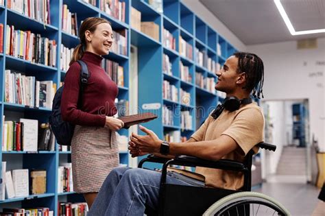 Estudiante Con Discapacidad Hablando Con Un Amigo En La Biblioteca