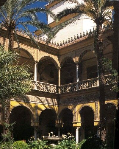 An Ornate Courtyard With Palm Trees And Other Plants