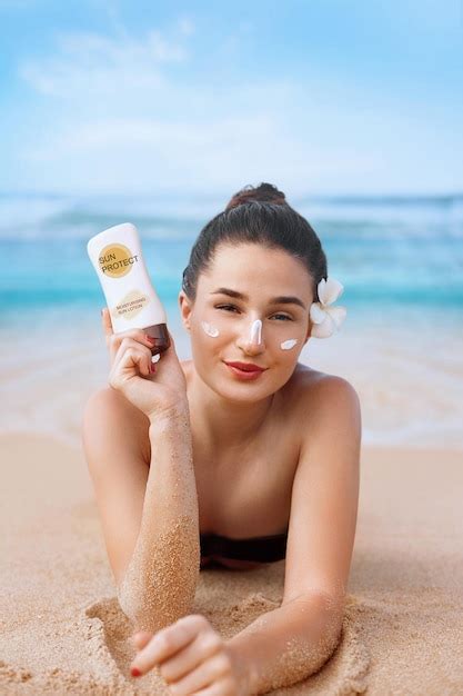 Beauté sexy jeune femme en bikini tenant des bouteilles de crème solaire dans ses mains Photo