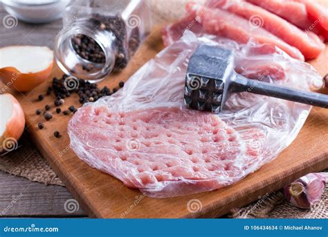 Fresh Raw Pork Chops Meat In A Bag On Chopping Board On Wooden Desk