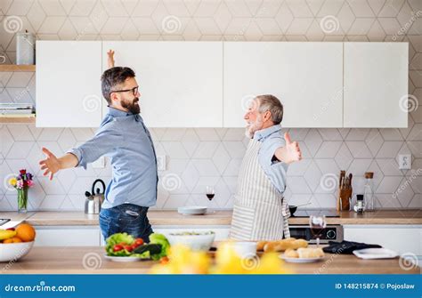 Adult Hipster Son And Senior Father Indoors In Kitchen At Home Having