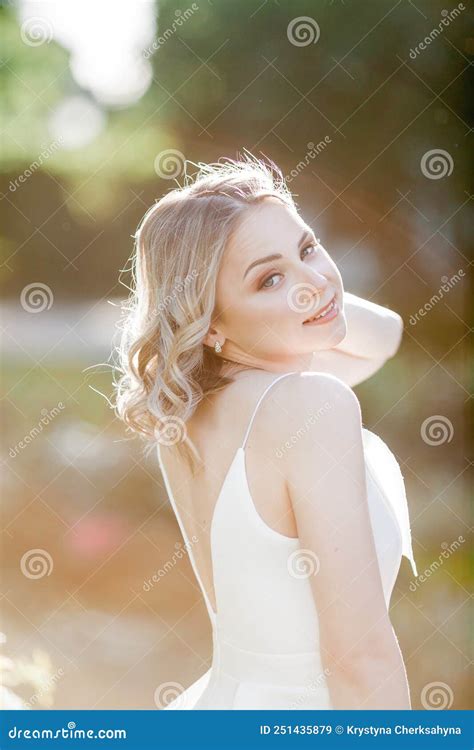 Mooie Blonde 20 Jarige Jongen Met Krullend Haar In Een Witte Jurk In De Zonnige Zonnestralen In