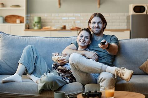 Jovem Casal Assistindo Tv Juntos Sentado No Sof E Segurando O