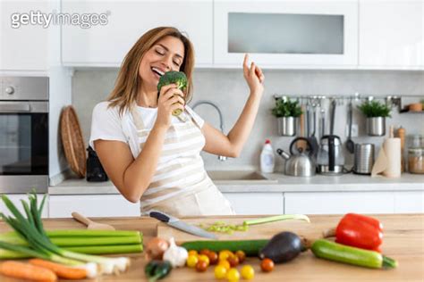 Excited Woman Singing And Dancing In Modern Kitchen At Home Happy