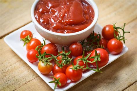 Ketchup En Tasse Et Tomates Fraîches Du Plat Blanc Fin Vers Le Haut