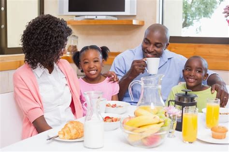 Família feliz tomando café da manhã juntos pela manhã Foto Premium