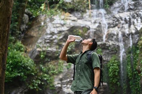 Un Excursionista Masculino Con Una Mochila Bebiendo Agua De Una Botella