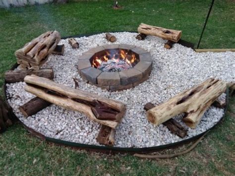 A Fire Pit Made Out Of Logs And Gravel