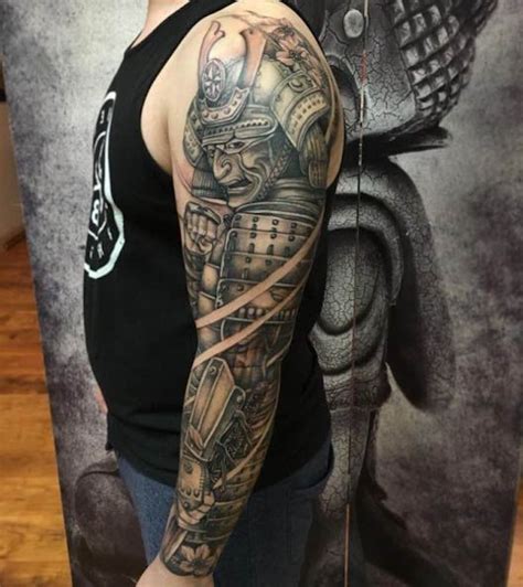 A Man With A Black And Grey Tattoo On His Arm