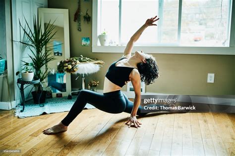 Woman In Low Lunge With Backbend Pose While Practicing Yoga In Bedroom