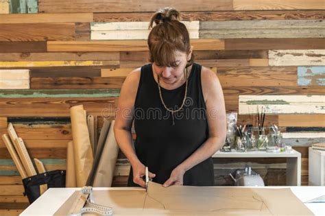 Fashion Designer Cutting Clothes Patterns At Her Studio Stock Photo