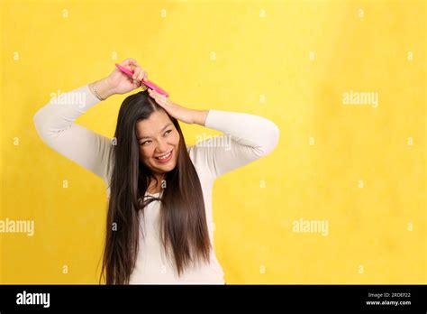 40 Year Old Latina Woman Brushes Her Straight Hair With Difficulty
