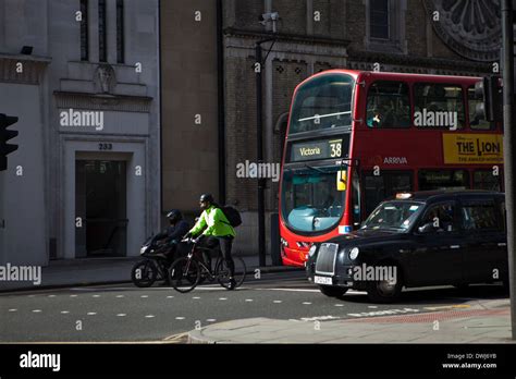 A London Bus Black Cab Cyclist And Motortcyclist Waiting At Traffic