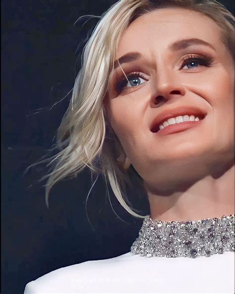 A Woman With Blonde Hair And Blue Eyes Wearing A White Dress Smiling At