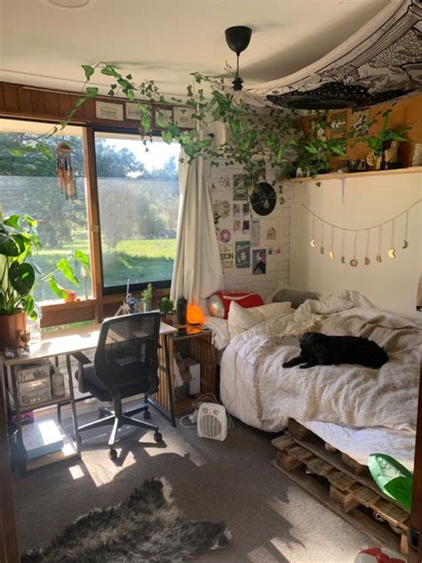 A Room With A Bed Desk And Window That Has Plants Growing On The Wall