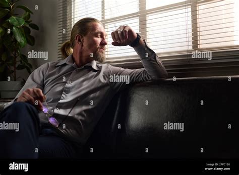 Mature Bearded Male Psychotherapist Looking Through Window Covered With