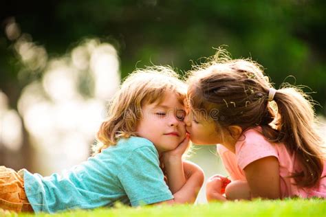 Cute Love Little Girl Kissing Boy Outdoors In Park Children