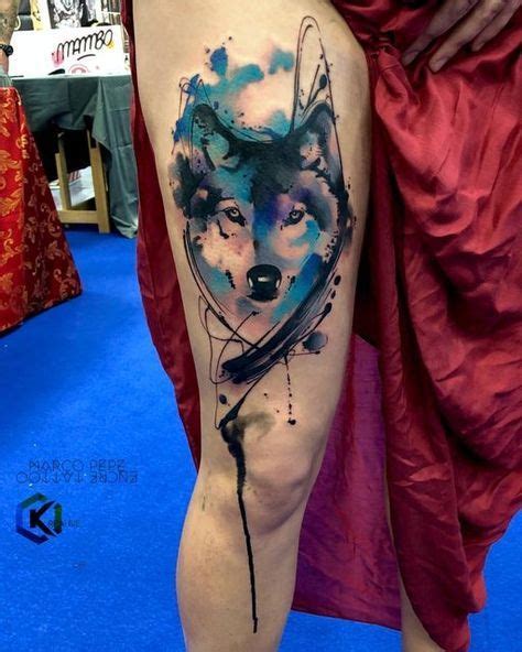 A Womans Thigh With A Tattoo Of A Wolf On It And Blue Watercolors