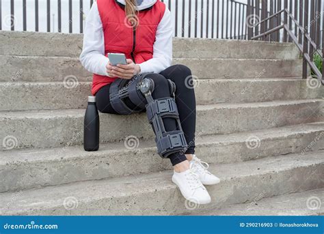 Woman Wearing Knee Brace Or Orthosis After Leg Surgery Walking In The