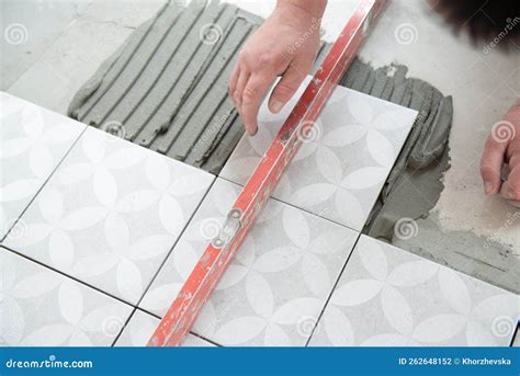 Tiler Laying The Ceramic Tile On The Floor Professional Worker Makes