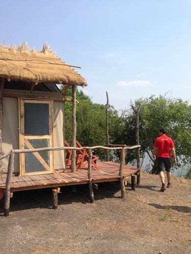 A Man Walking Towards A Small Hut On A Wooden Platform