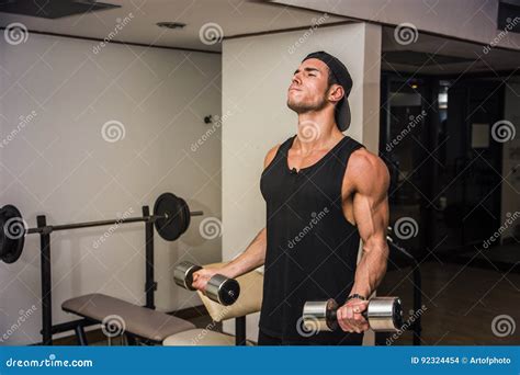 Homem Novo Consider Vel Que Exercita O B Ceps No Gym Foto De Stock