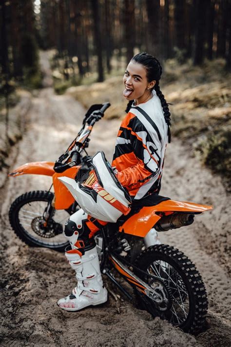 Beautiful Young Female Racer Riding Motocross Bike On A Trail Of Sand