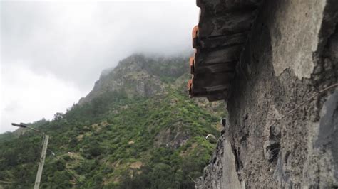 Close Up Of Old Stone Building Side And Roof With Foggy Mountain