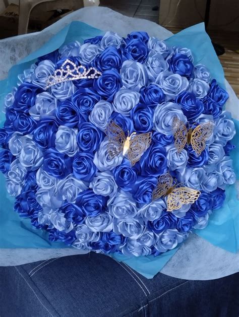 A Bouquet Made Out Of Blue Roses With Butterflies On It Sitting On A