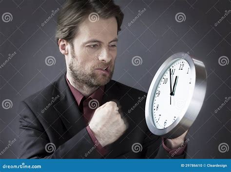 Office Worker Under Time Pressure Punching Clock With His Fist Stock