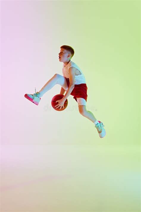 Motivated Teen Boy Basketball Player In Dynamic Pose With Ball