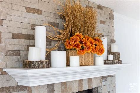 A Mantle With Candles And Flowers On It In Front Of A Brick Fireplace