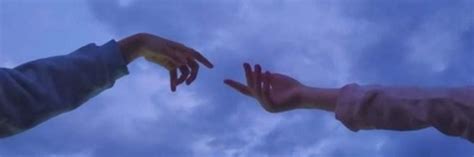 Two Hands Reaching Out Towards Each Other In The Air Against A Blue Sky