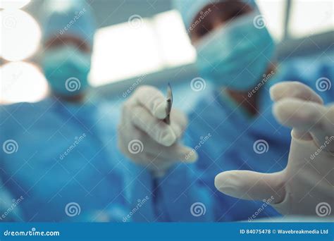 Surgeon With Scalpel Performing Operation In Operation Theater Stock