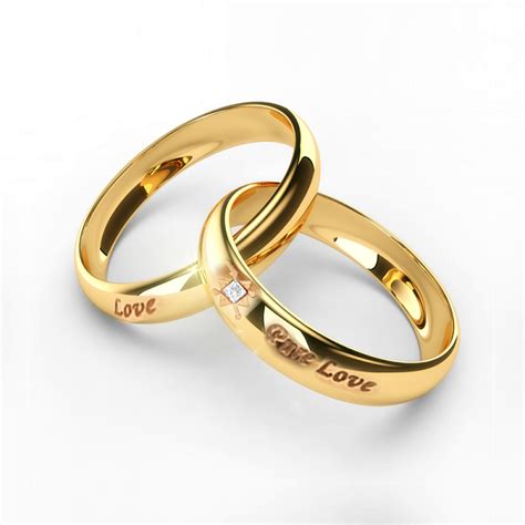 Two Gold Wedding Rings With The Word Love Written On Each One And