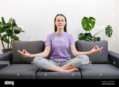 No Stress Concept Calm Young Woman Sit Cross Legged On Comfy Sofa In