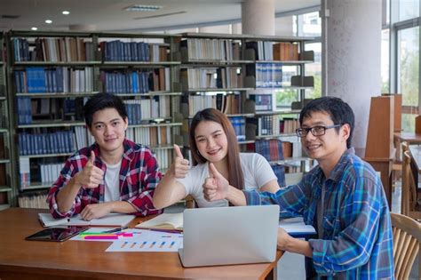 Estudiantes universitarios asiáticos leen libros y estudian juntos en