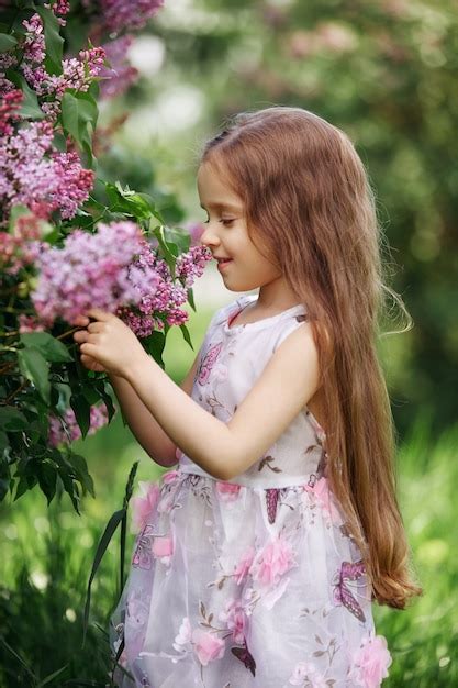 Premium Photo Beautiful Girl In A Dress Posing Near Bush Lilacs